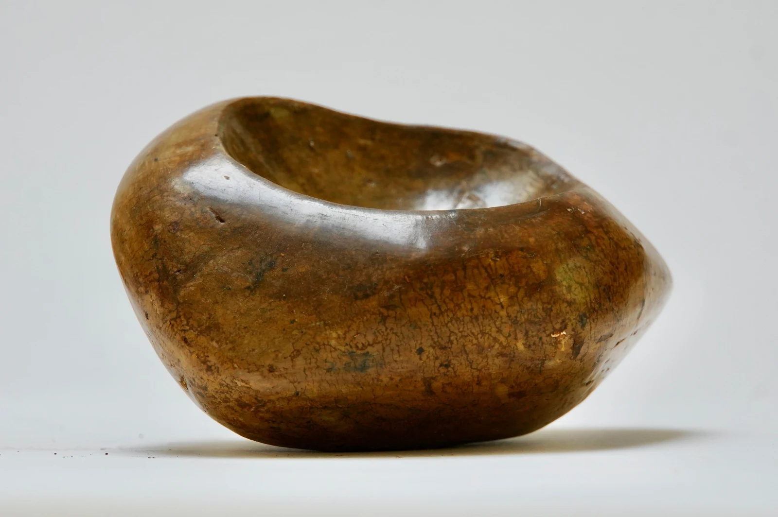 Bedrock by Edie Evans, a polished clay vessel with a deep hollow, seen from the side