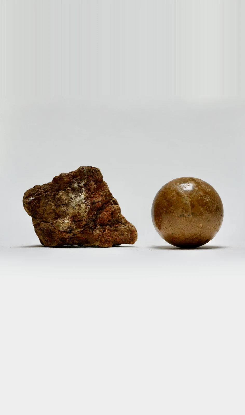 Earth Memory by Edie Evans, a rough rock of excavated earth beside a polished clay sphere