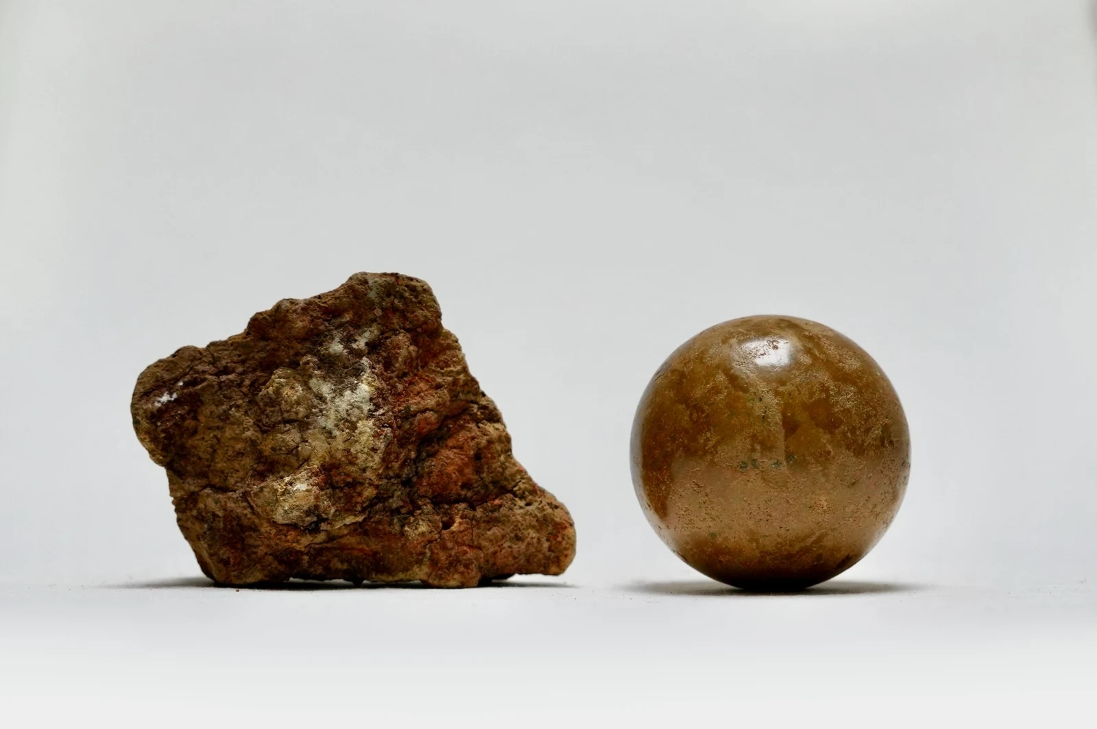 Earth Memory by Edie Evans, a rough rock of excavated earth beside a polished clay sphere