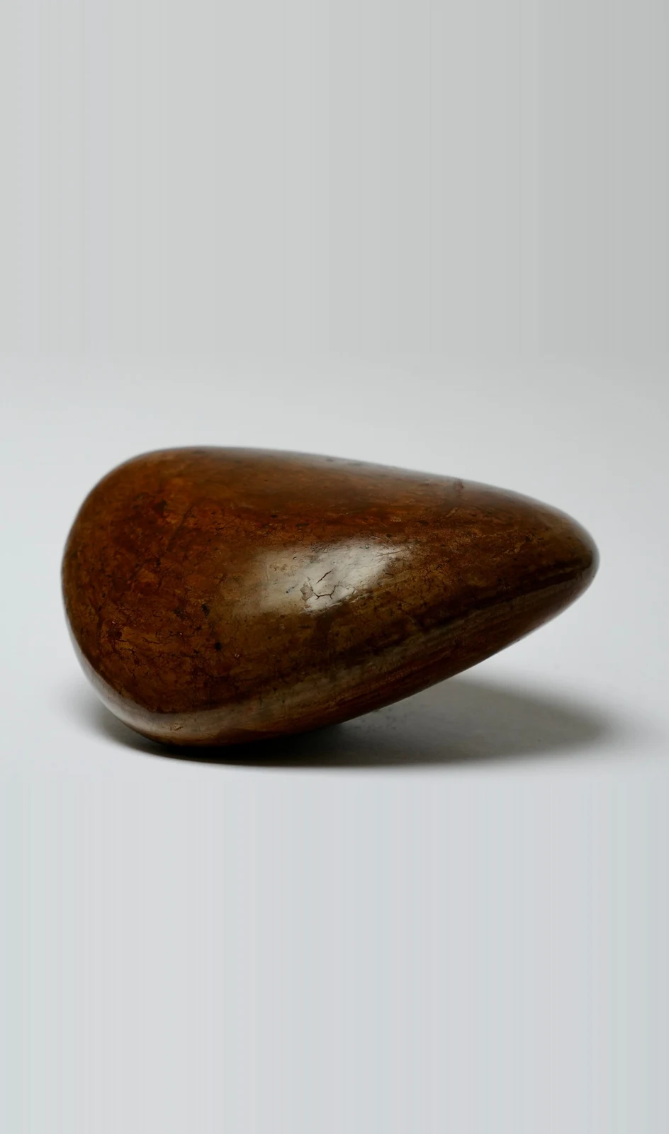 Ground by Edie Evans, a polished clay teardrop form resting on its side