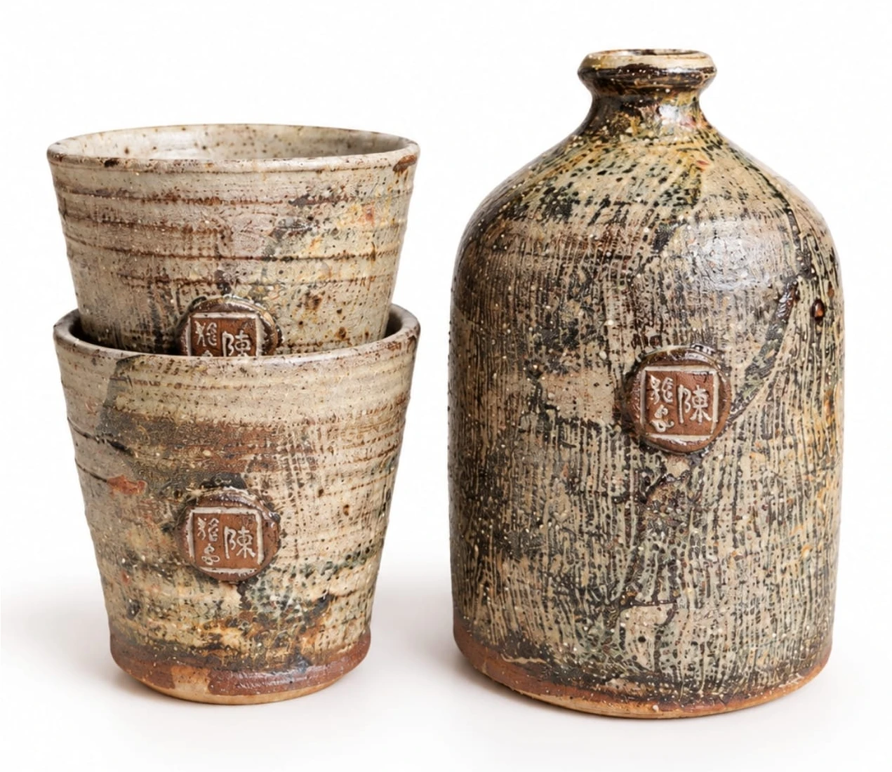 Sake Set #3 by Jacob Chan, two stacked pale speckled cups beside a textured stone-coloured bottle